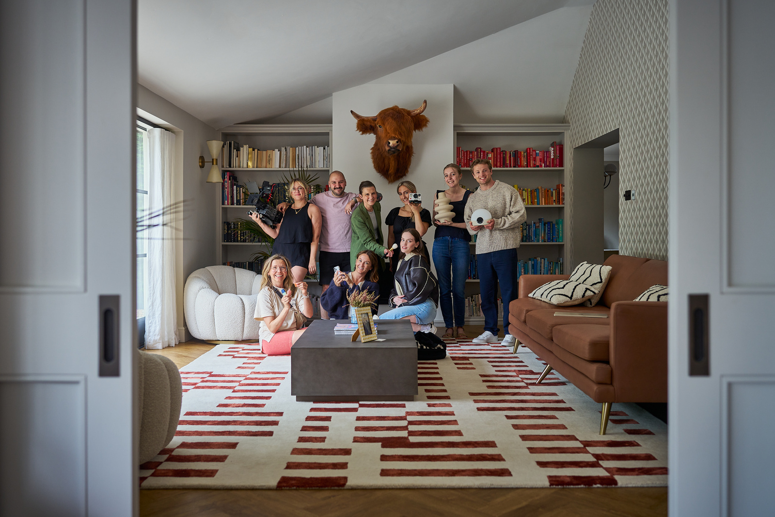 A group of people pose indoors for a photograph. 