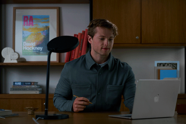 A gif of a man in an office adjusting a Lumie lamp. 