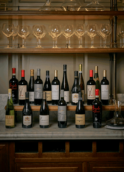Two rows of wine bottles jump around the image in a posh restaurant. 