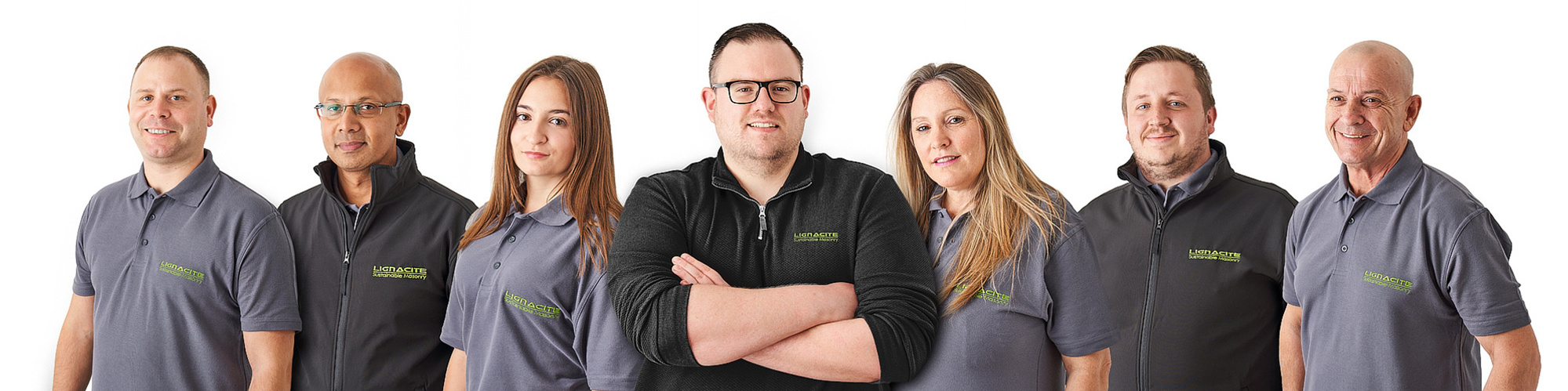 A group portrait of seven team members photographed on a white back ground. 