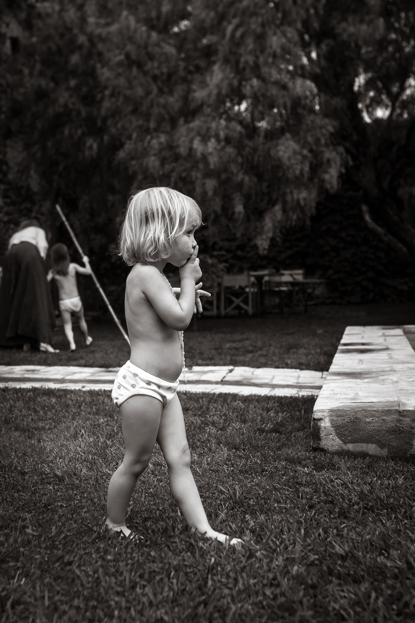niña pequeña caminando en el jardín de su casa sin ropa, la Bisbal de baix Empordá, cataluña