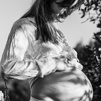 fotografía de barriga de embarazada  de 38 semanas, en los campos floridos de Pla de l'Estany, en girona, españa.