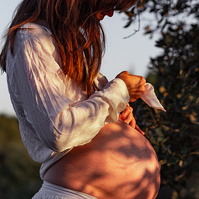fotografía de barriga de embarazada  de 38 semanas, en los campos floridos de Pla de l'Estany, en girona, españa.
