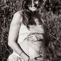 retrato sentada de una mamá embarazada de 38 semanas, en los campos floridos de Pla de l'Estany, en girona, españa.