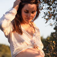 fotografía de barriga de embarazada  de 38 semanas, en los campos floridos de Pla de l'Estany, en girona, españa.