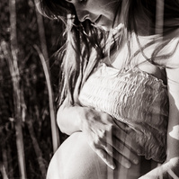 retrato sentada de una mamá embarazada de 38 semanas, en los campos floridos de Pla de l'Estany, en girona, españa.