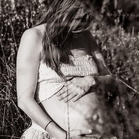 retrato sentada de una mamá embarazada de 38 semanas, en los campos floridos de Pla de l'Estany, en girona, españa.