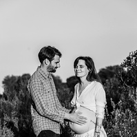 fotografía de una pareja ella está embarazada  de 38 semanas, en los campos floridos de Pla de l'Estany, en girona, españa.