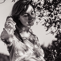 fotografía de barriga de embarazada  de 38 semanas, en los campos floridos de Pla de l'Estany, en girona, españa.