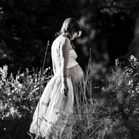 retrato de pie de una mamá embarazada de 38 semanas, en los campos floridos de Pla de l'Estany, en girona, españa.