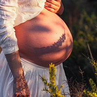 fotografía de barriga de embarazada  de 38 semanas, en los campos floridos de Pla de l'Estany, en girona, españa.