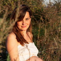 retrato sentada de una mamá embarazada de 38 semanas, en los campos floridos de Pla de l'Estany, en girona, españa.