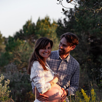 fotografía de una pareja ella está embarazada  de 38 semanas, en los campos floridos de Pla de l'Estany, en girona, españa.