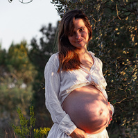 fotografía de barriga de embarazada  de 38 semanas, en los campos floridos de Pla de l'Estany, en girona, españa.