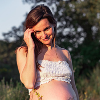 fotografía de barriga de embarazada  de 38 semanas, en los campos floridos de Pla de l'Estany, en girona, españa.