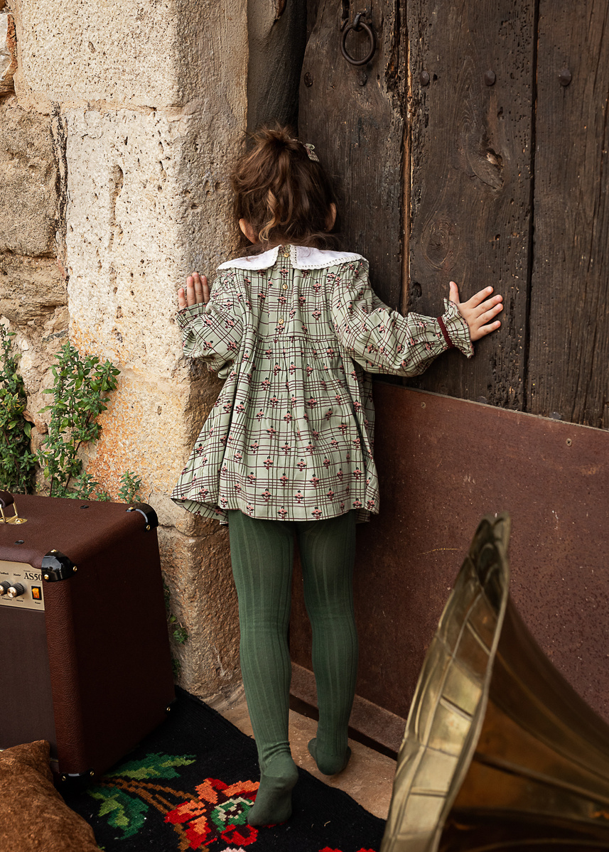 Niña curiosa mirando por la puerta de una casa,  FW 21-22 campaign for the kids fashion brand Bachaā at a farmhouse at l'empordà, Spain 