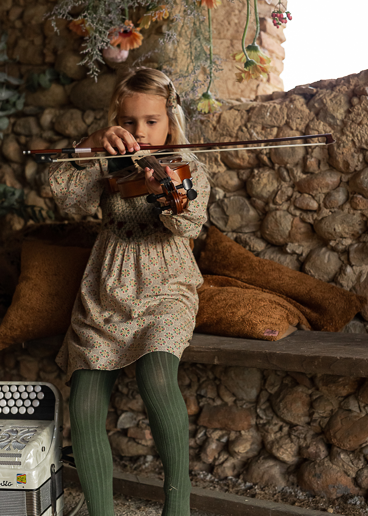 niña tocando el violin, en un pajar de una Masia en Pla de l'Estany, girona, españa
