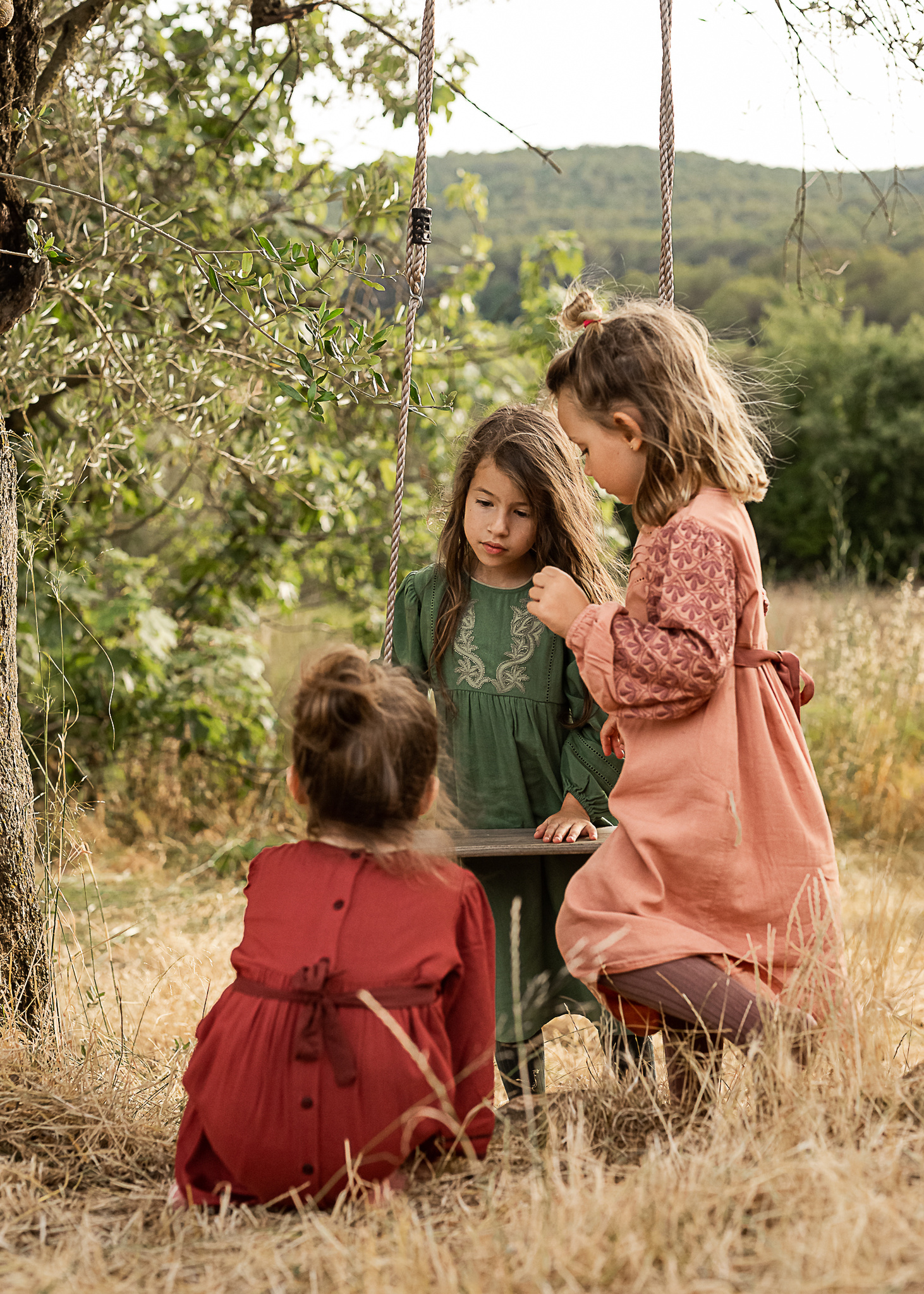 niñas columpiándose en el jardin de una Masia en Pla de l'Estany en cataluña, españa.