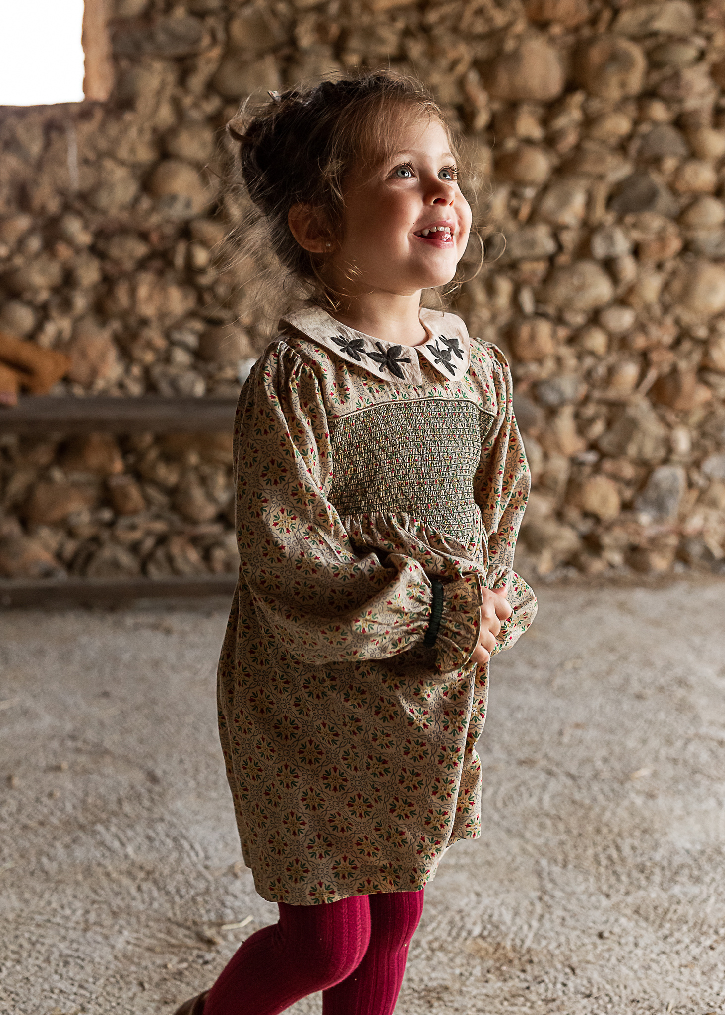 niña sonriendo en un pajar de una Masia en Pla de l'Estany, girona, españa