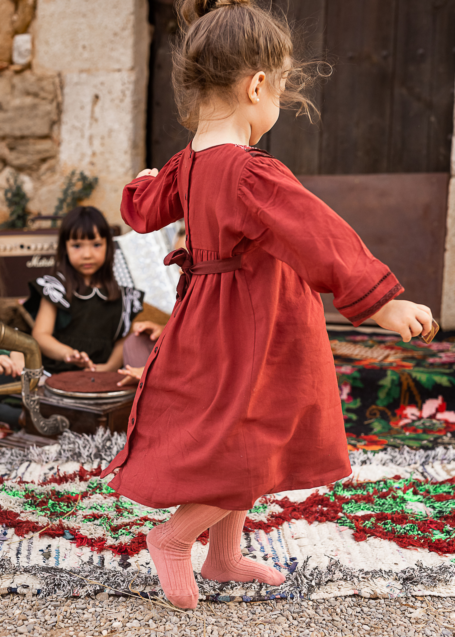 niña dando vuelta a su vestido en el portal de una Masia en Pla de l'Estany en cataluña, españa.