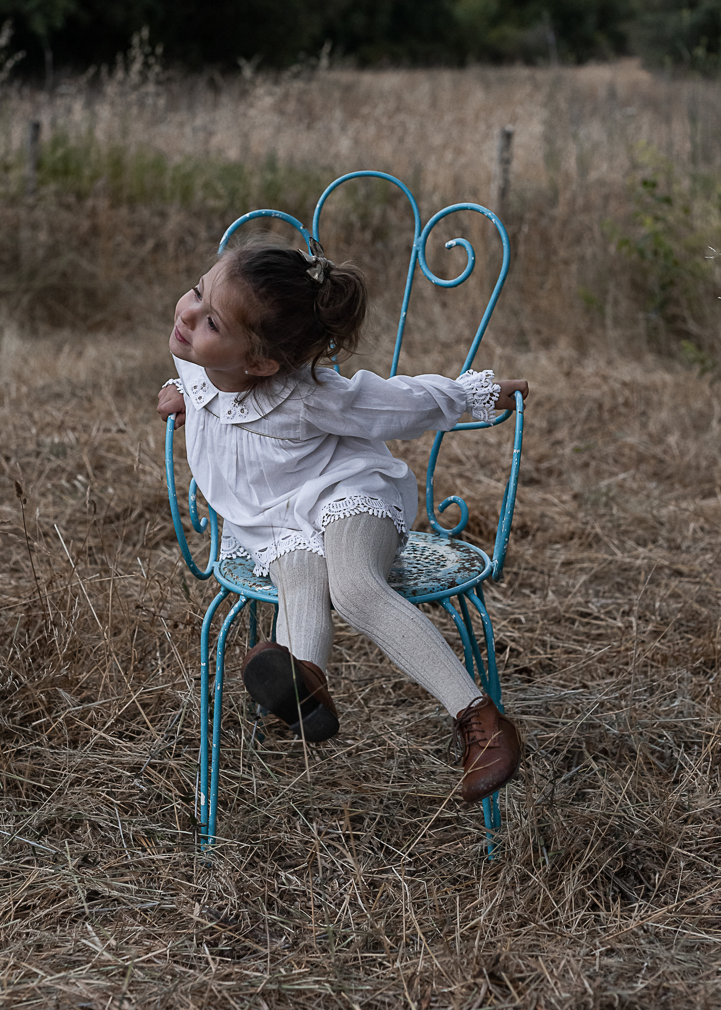 niña en una silla de un jardín del Pla de l'Estany en cataluña, españa