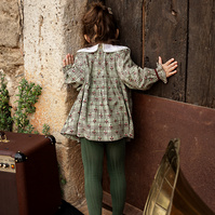 Niña curiosa mirando por la puerta de una casa,  FW 21-22 campaign for the kids fashion brand Bachaā at a farmhouse at l'empordà, Spain 