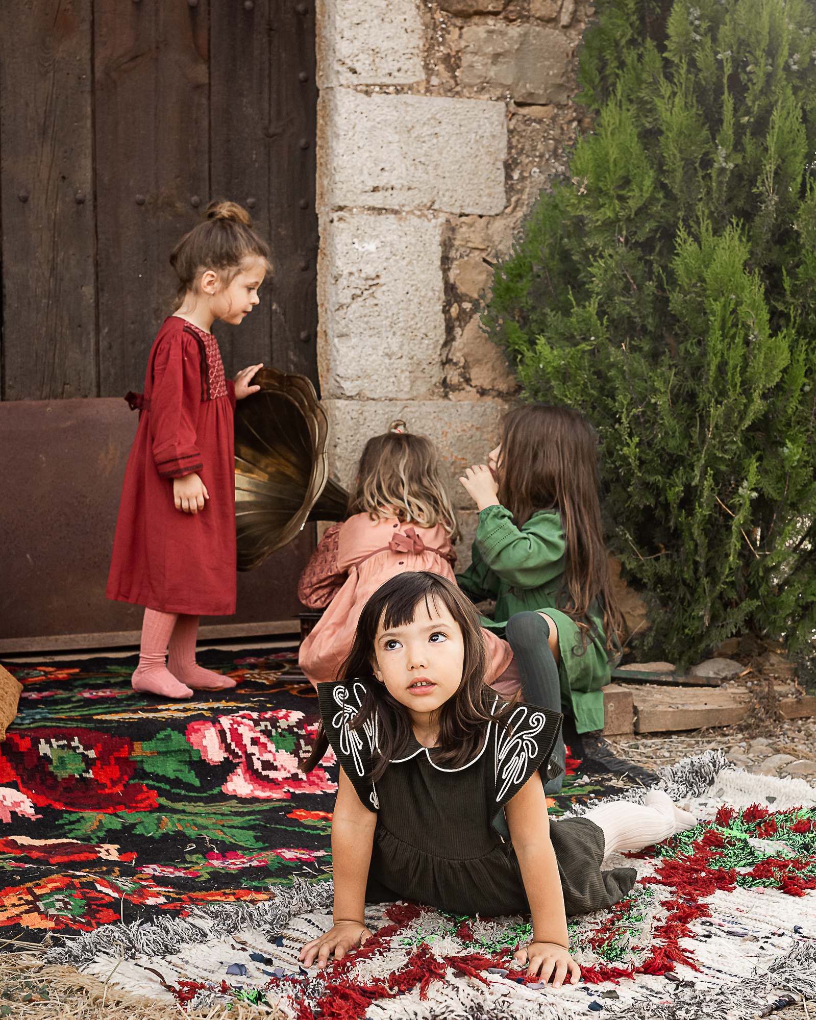 cuatro niñas sentadas en el portal de una Masia en Pla de l'Estany en cataluña, españa.