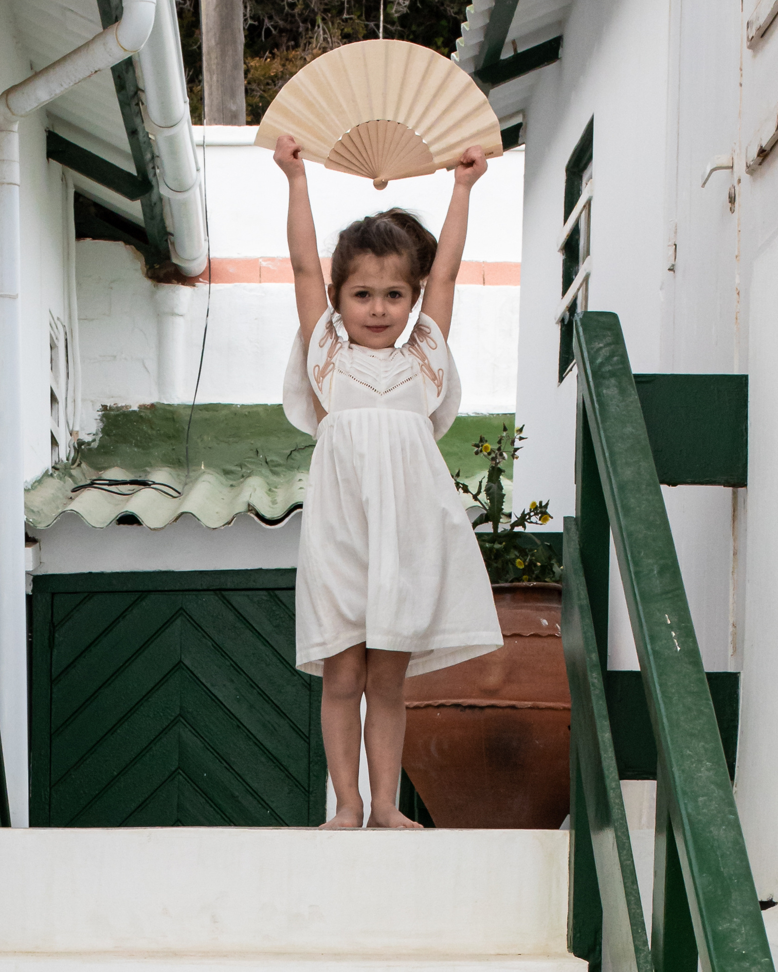 niña jugando con abanico en la playa las casetas del Garraf en barcelona, españa