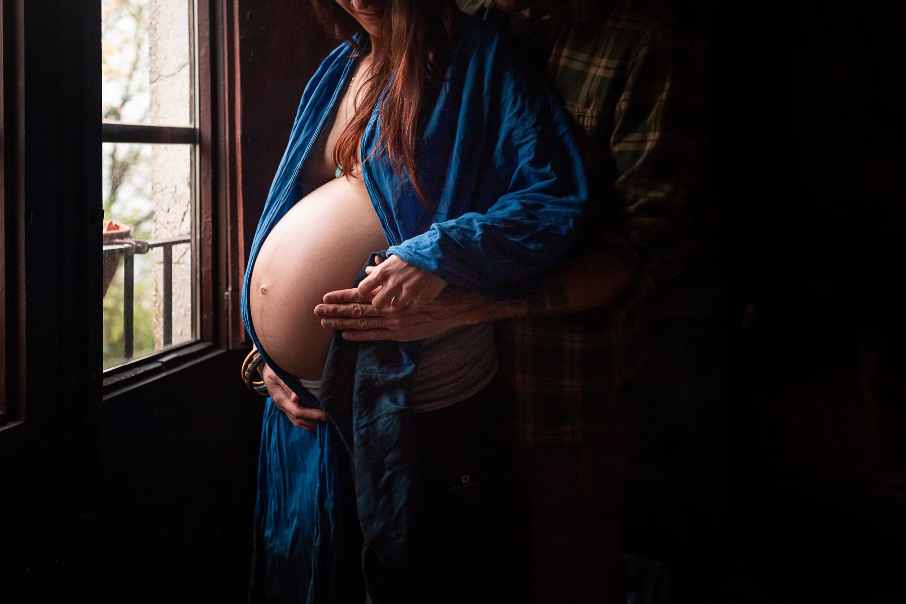 Mujer embarazada se toca el vientre cerca de su ventana en Olot, la garrota
