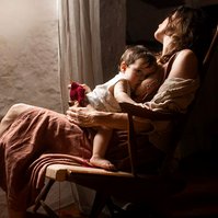 Madre reposando en una silla amamantando a su bebe, cerca de una ventana, plà del Estany, cataluña, españa