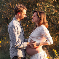 fotografía de una pareja ella está embarazada  de 38 semanas, en los campos floridos de Pla de l'Estany, en girona, españa.
