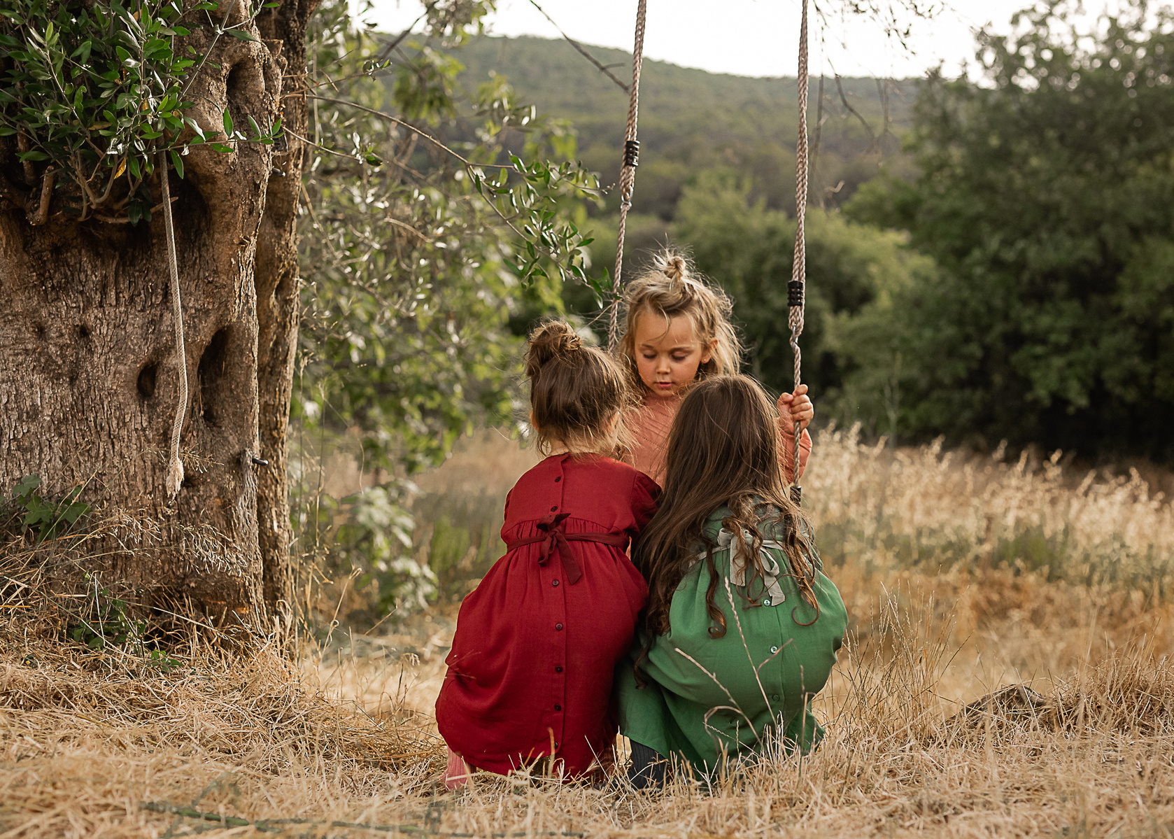 niñas columpiándose en el jardin de una Masia en Pla de l'Estany en cataluña, españa.