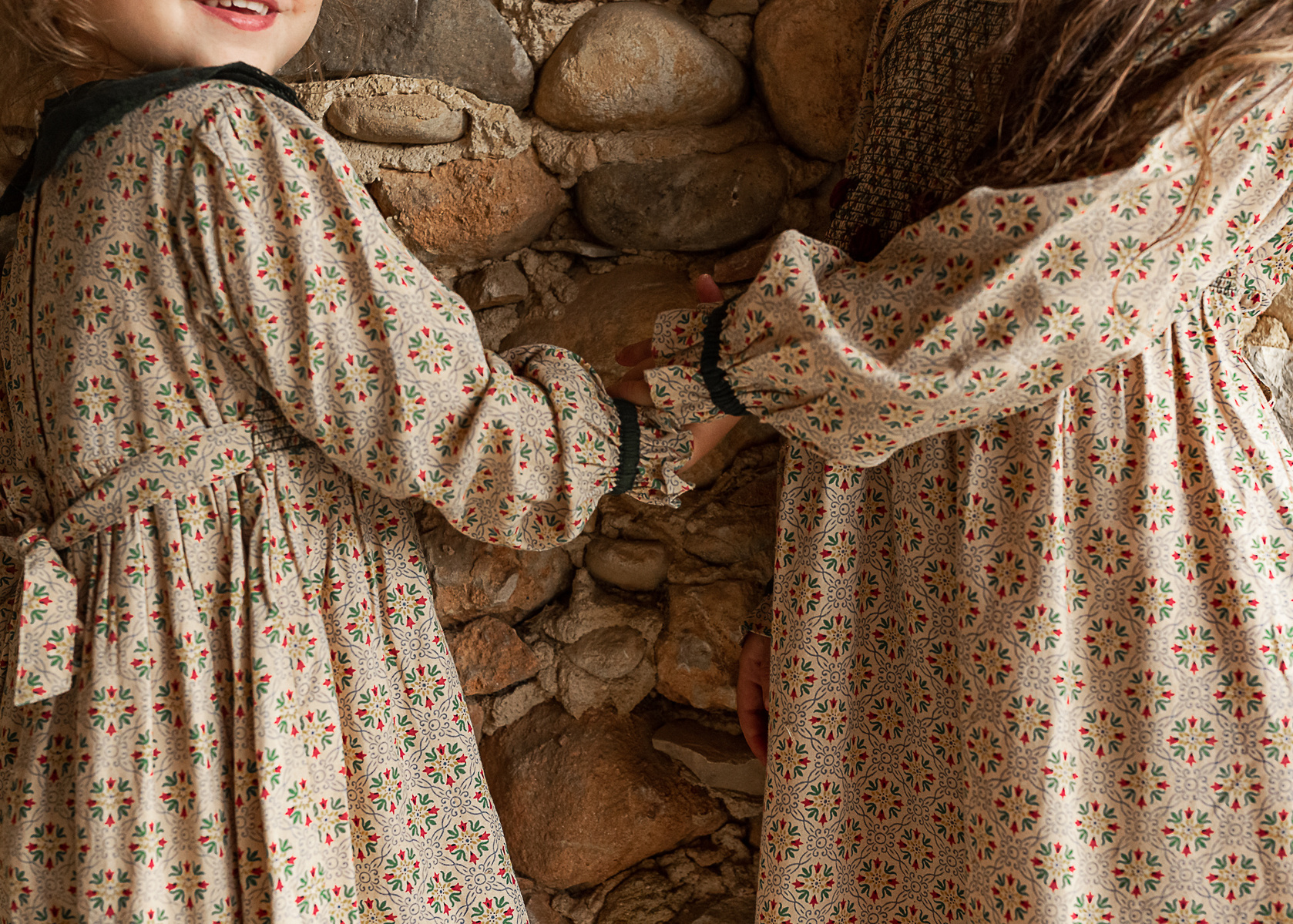 detalle de niñas cogidas de la mano  en un pajar de una Masia en Pla de l'Estany, girona, españa
