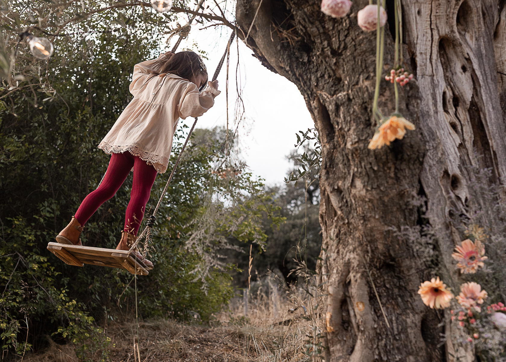  una niña en un columpio en el jardín de una Masia del Pla de l'Estany, girona, españa.