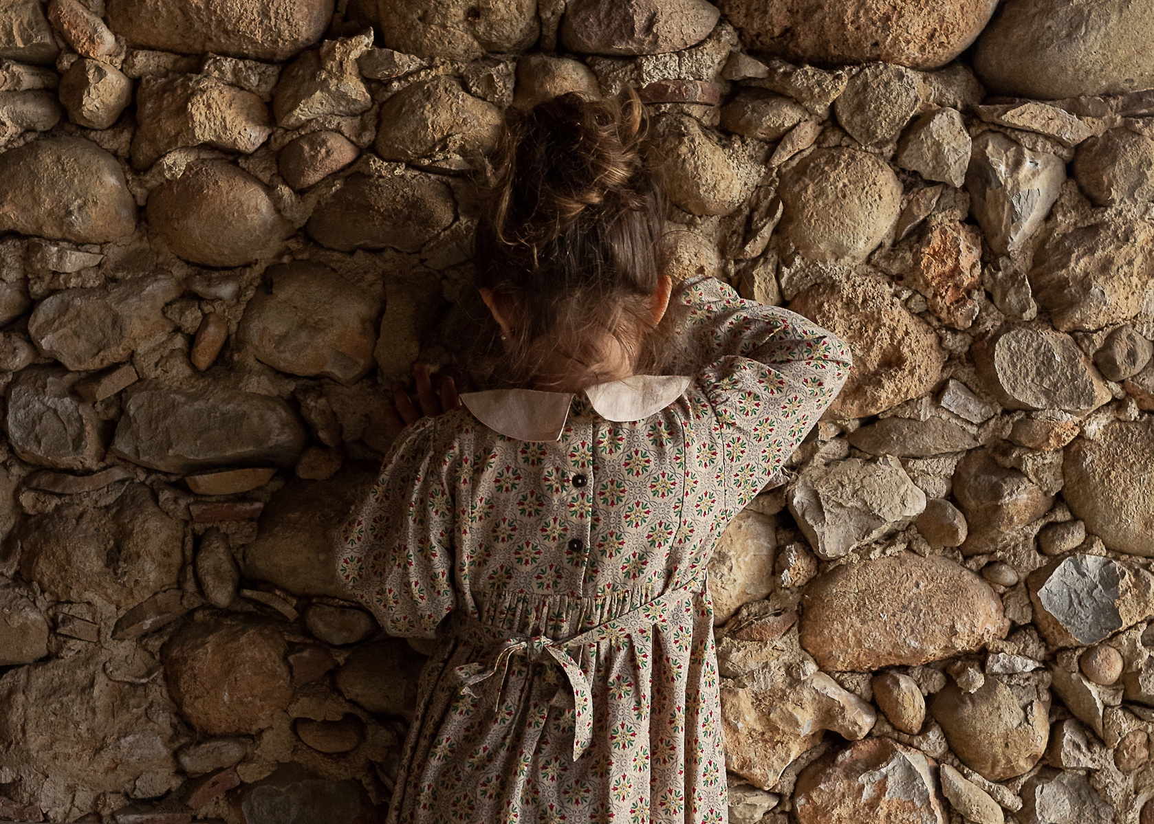 niña cabeza escondida, en un pajar de una Masia en Pla de l'Estany, girona, españa
