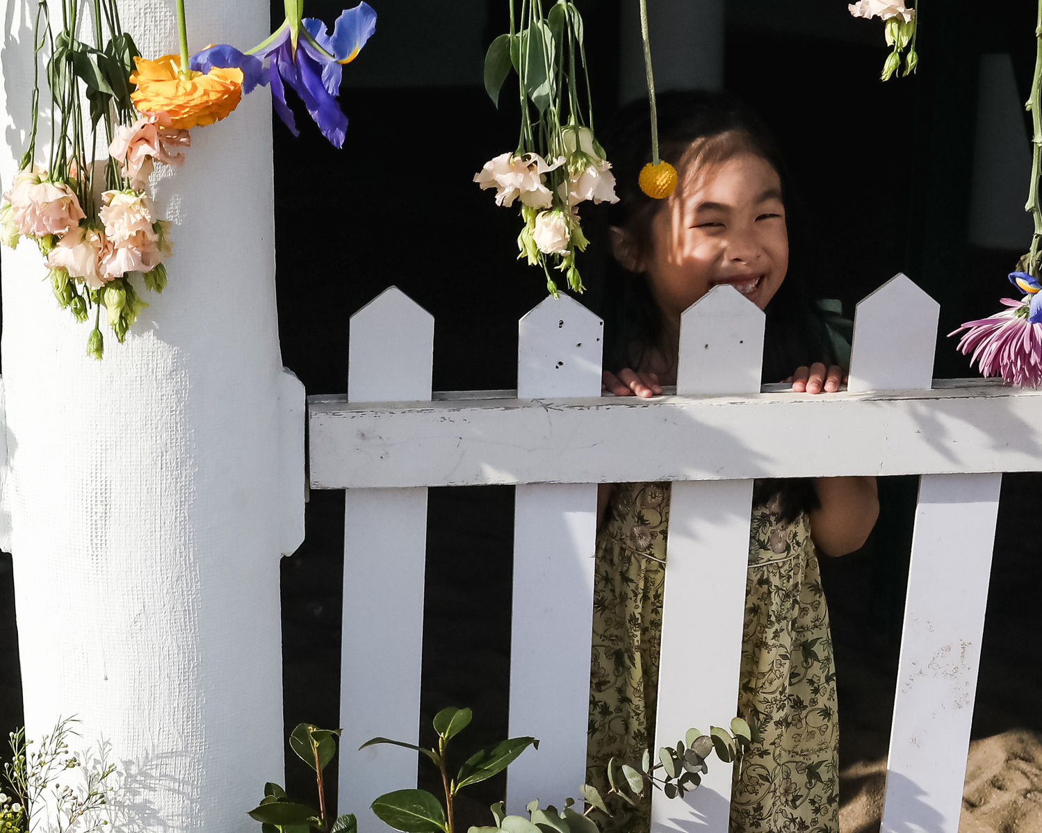 niña sonriendo detrás de el portal de una casa en la playa de les casetas del Garraf en Barcelona, españa
