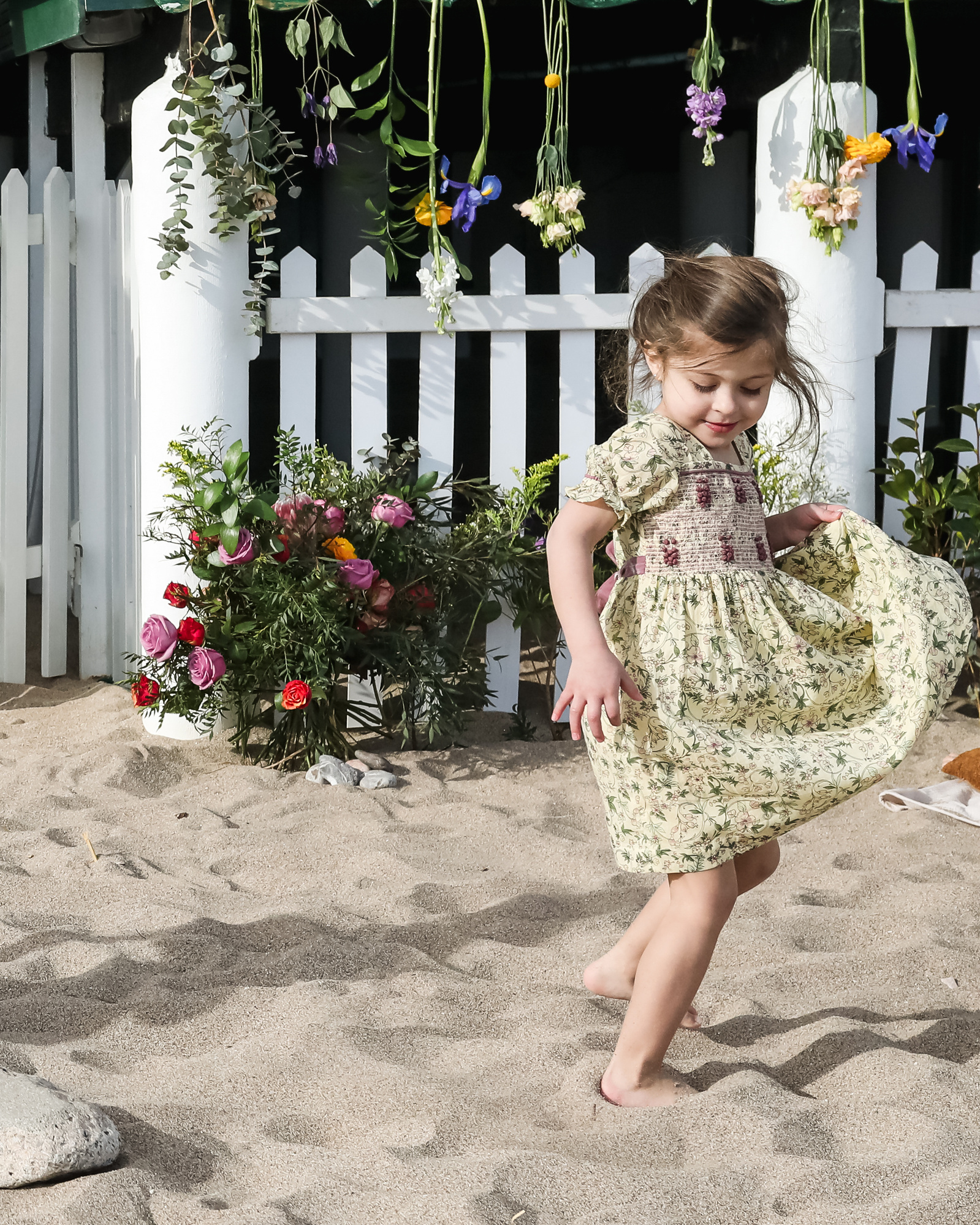 niña da vueltas a su vestido delante de les casetas del Garraf en Barcelona, españa