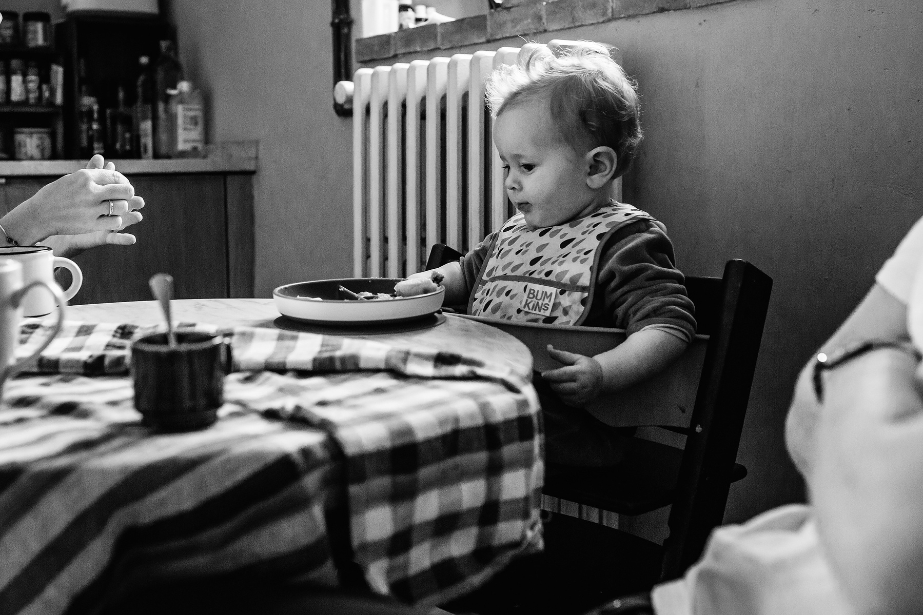 dos mamás compartiendo con su bebé en la mesa de la cocina, Manuela Franjou fotografia de familia