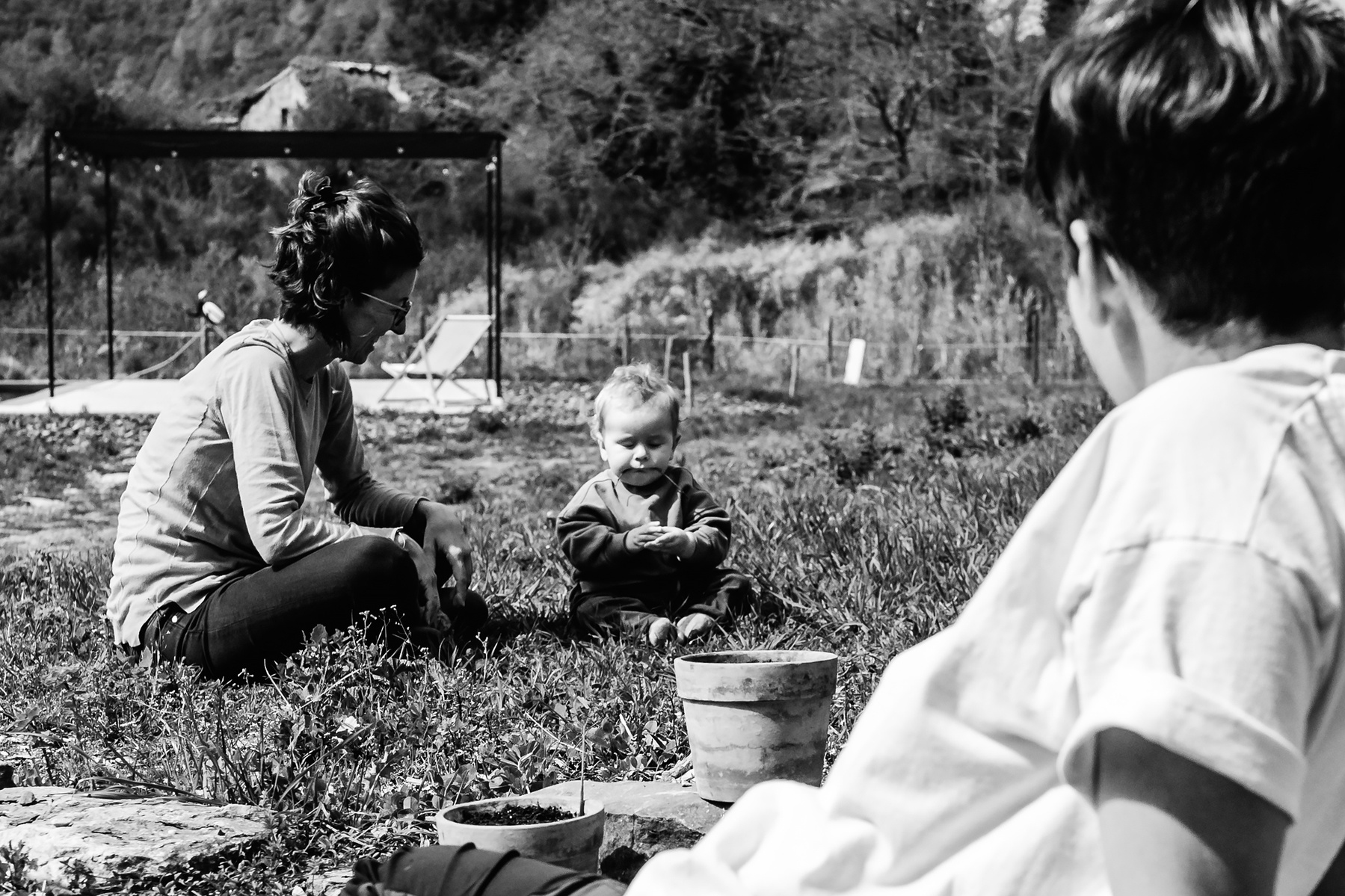 mamás jugando con su bebé en el jardín de su casa,  fotografia de familia Manuela Franjou
