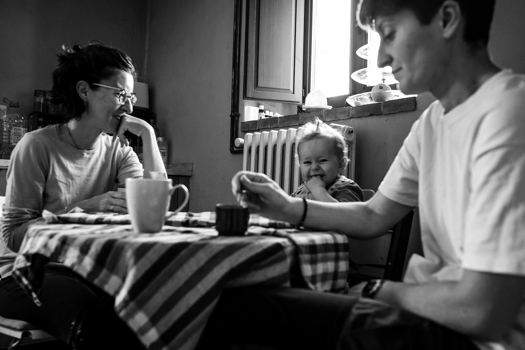 dos mamás compartiendo con su bebé en la mesa de la cocina, Manuela Franjou fotografia de familia