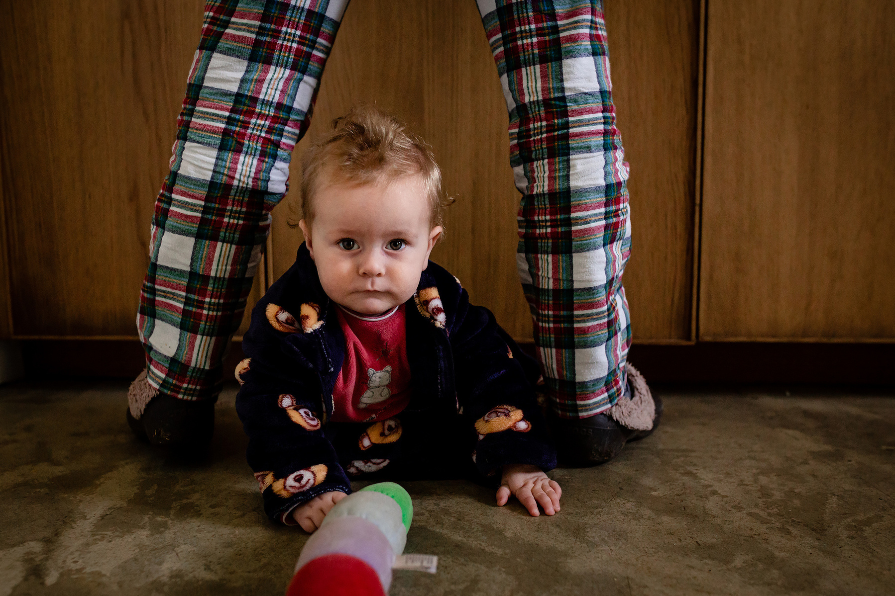 mamá limpiando en la pica de la cocina, bebé mirándola ,  fotografia de familia Manuela Franjou