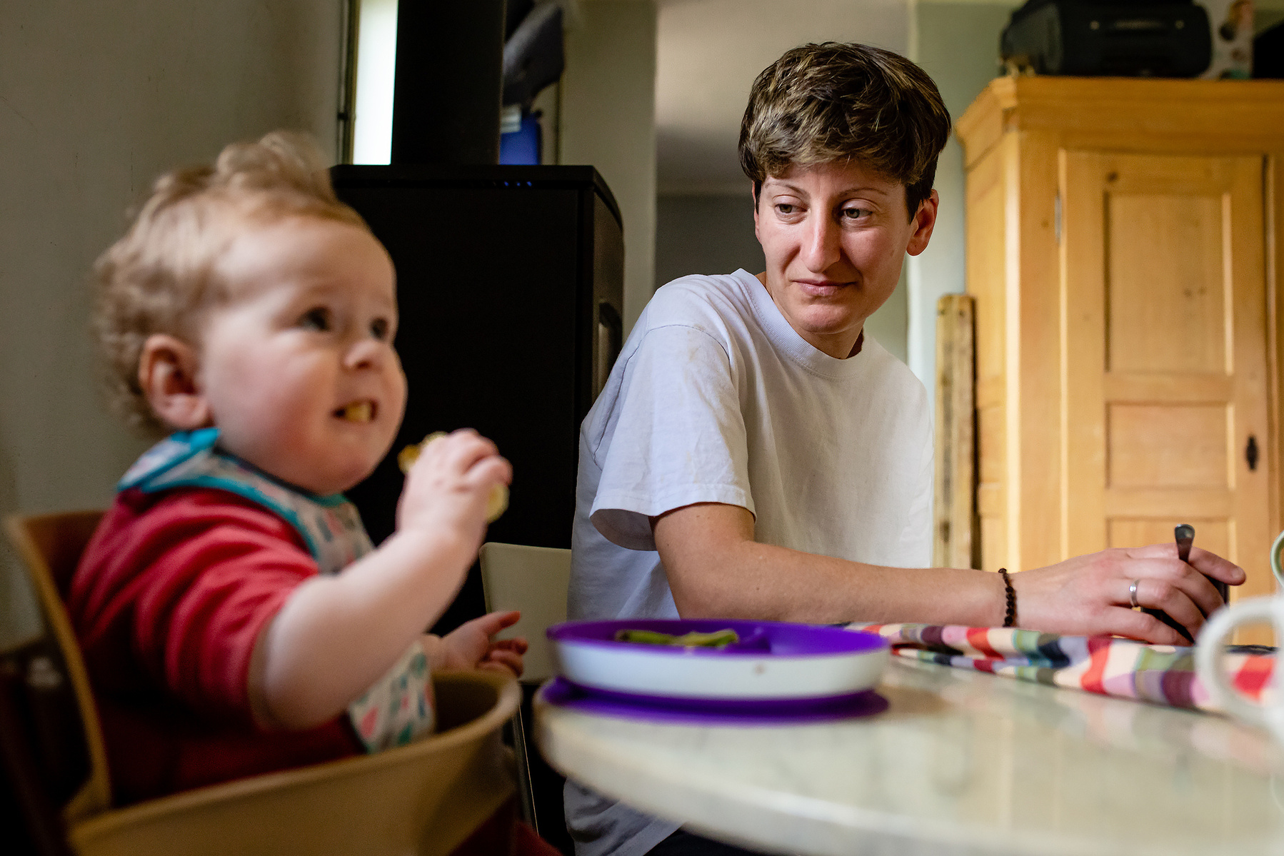 mamá observando a su bebé en la mesa de la cocina, Manuela Franjou fotografia de familia
