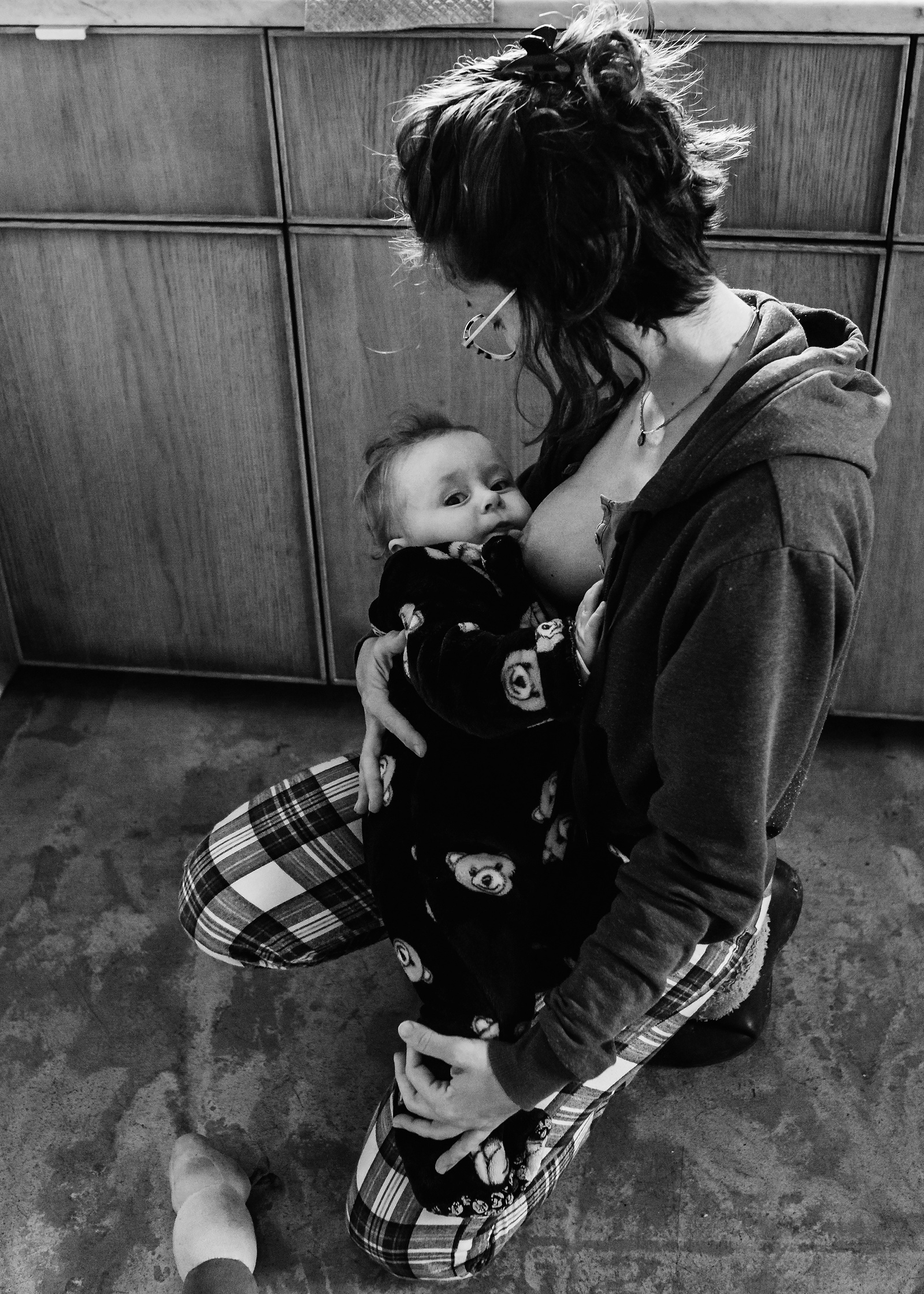 Madre dando el pecho en su cocina a su hijo de 11 meses. Fotografía de familia, Manuela Franjou