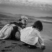 dos niños pequeños jugando con la arena en la playa del Empordá en invierno