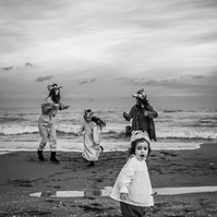 cuatro hermanos jugando con las olas del mar del Empordá en invierno