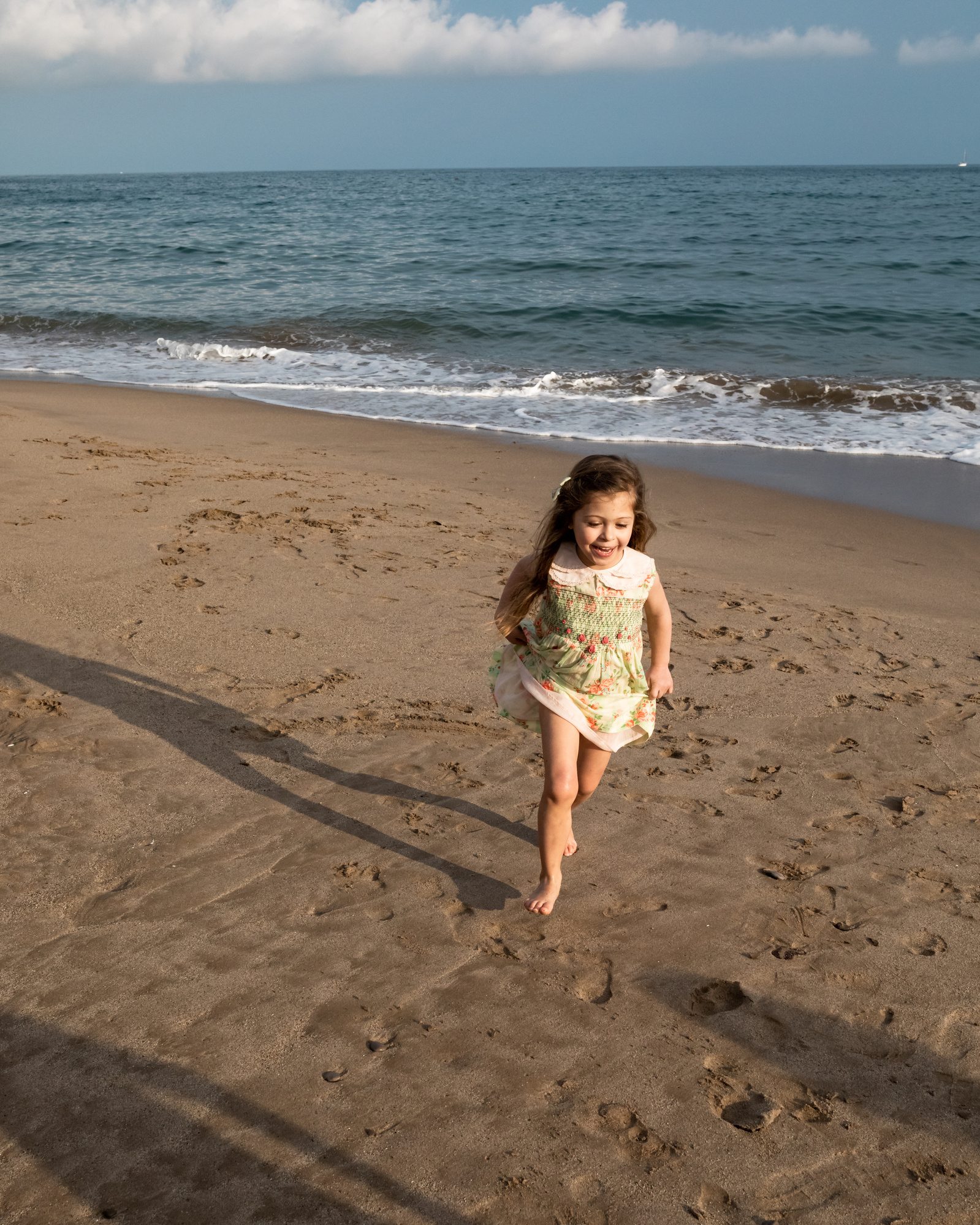 niña corriendo por la arena en el atardecer, en la playa las casetas del Garraf en barcelona, españa