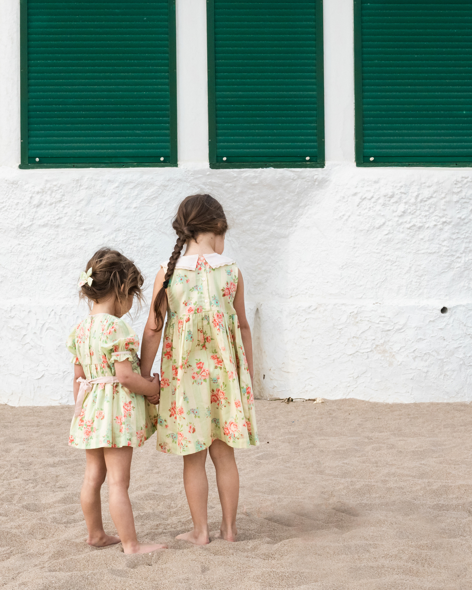 dos niñas de la mano en la playa las casetas del Garraf en barcelona, españa