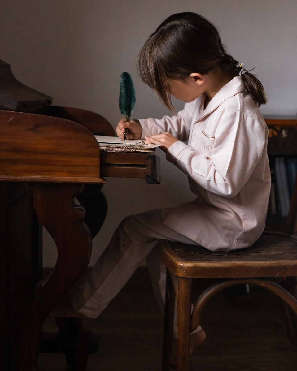 niña escribiendo una carta en un escritorio antiguo,  FW 21-22 pijamas capsule campaign for the kids fashion brand Bachaā  and calisperia at l'empordà, spain