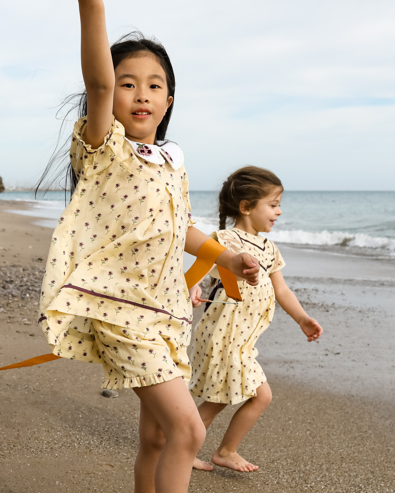 dos niñas corriendo hacia la playa en les casetas del Garraf en Barcelona, españa