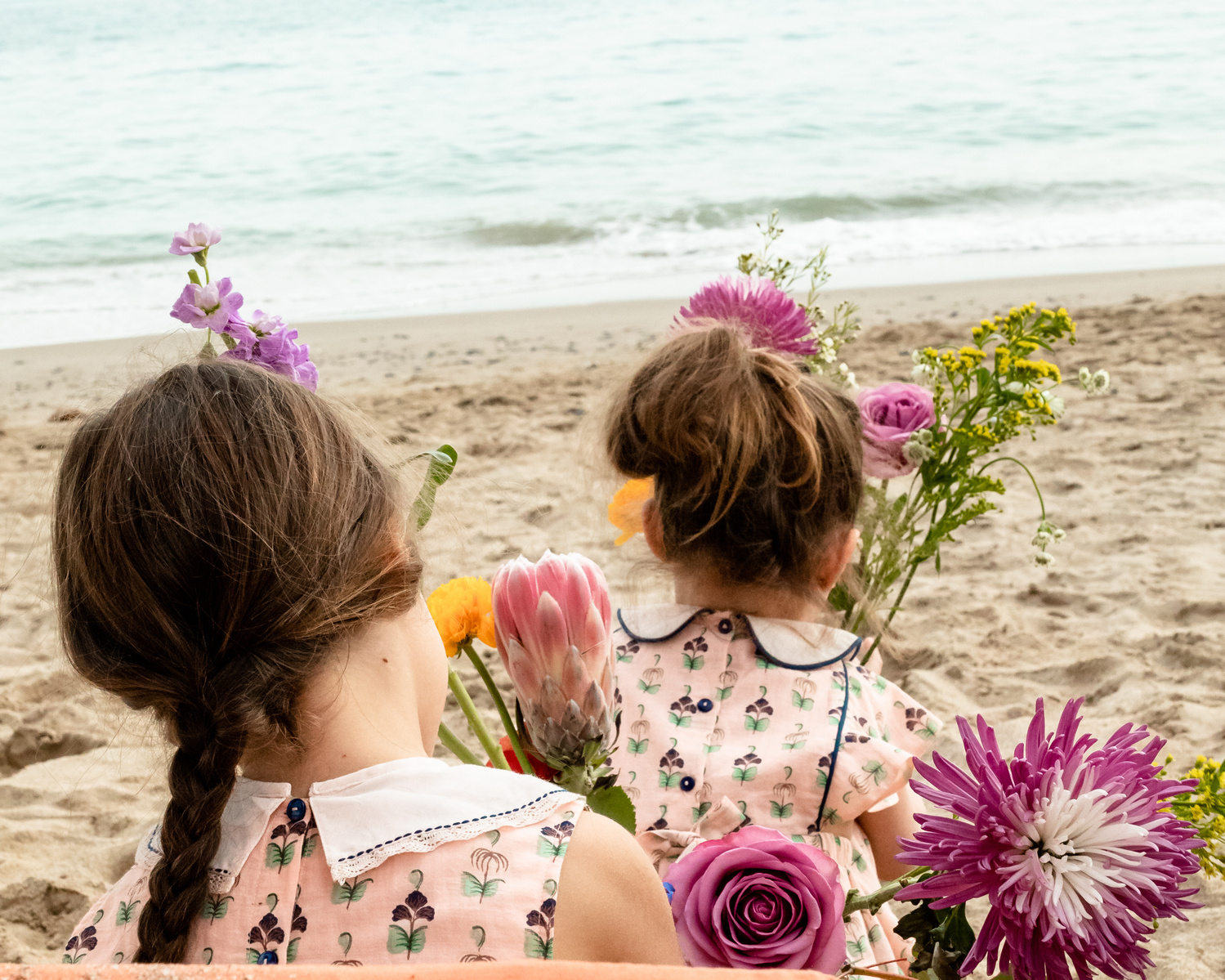 dos niñas mirando hacia el mar en la playa las casetas del Garraf en barcelona, españa